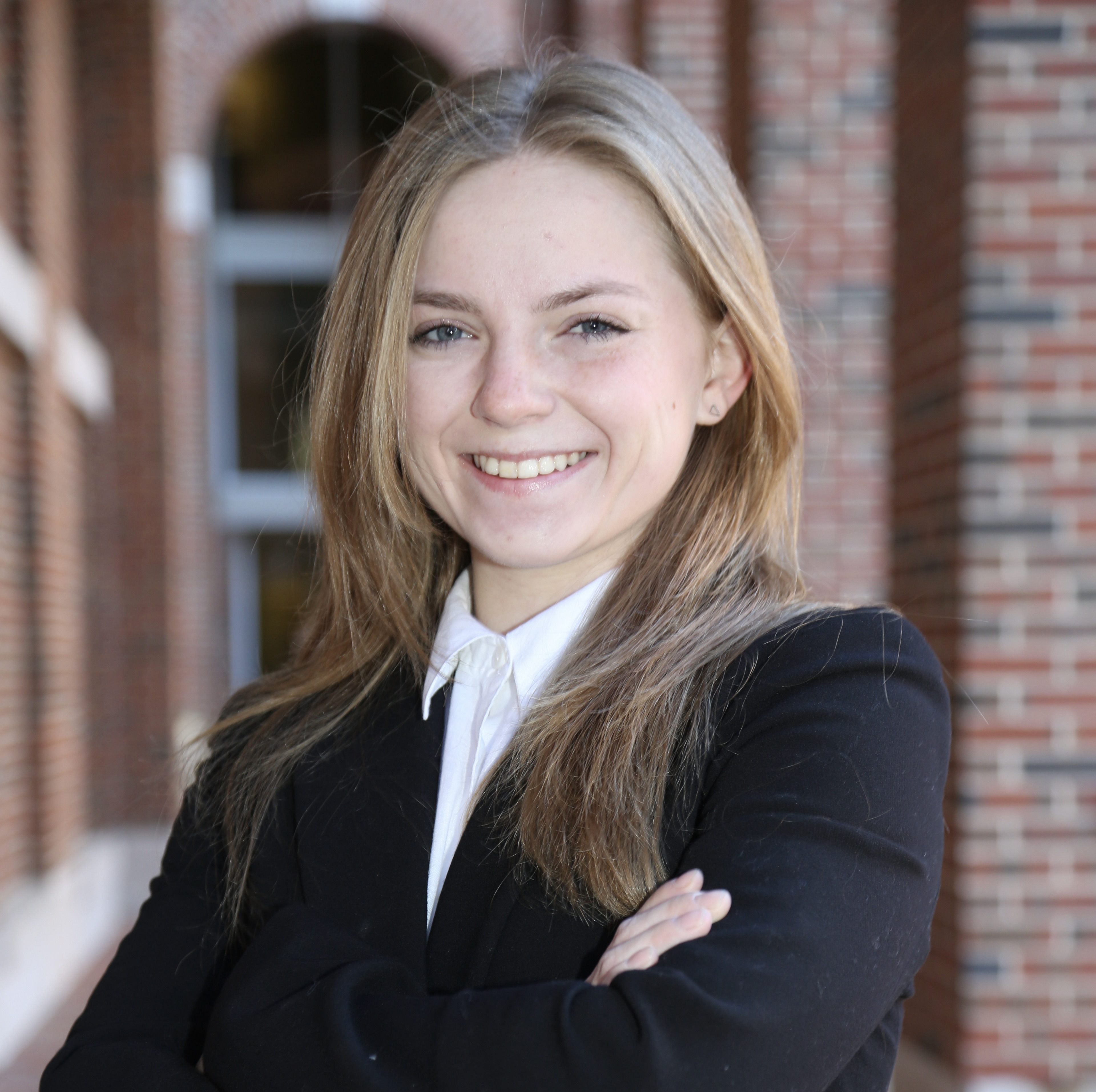 Meredith Clark in a black blazer, smiling with arms crossed