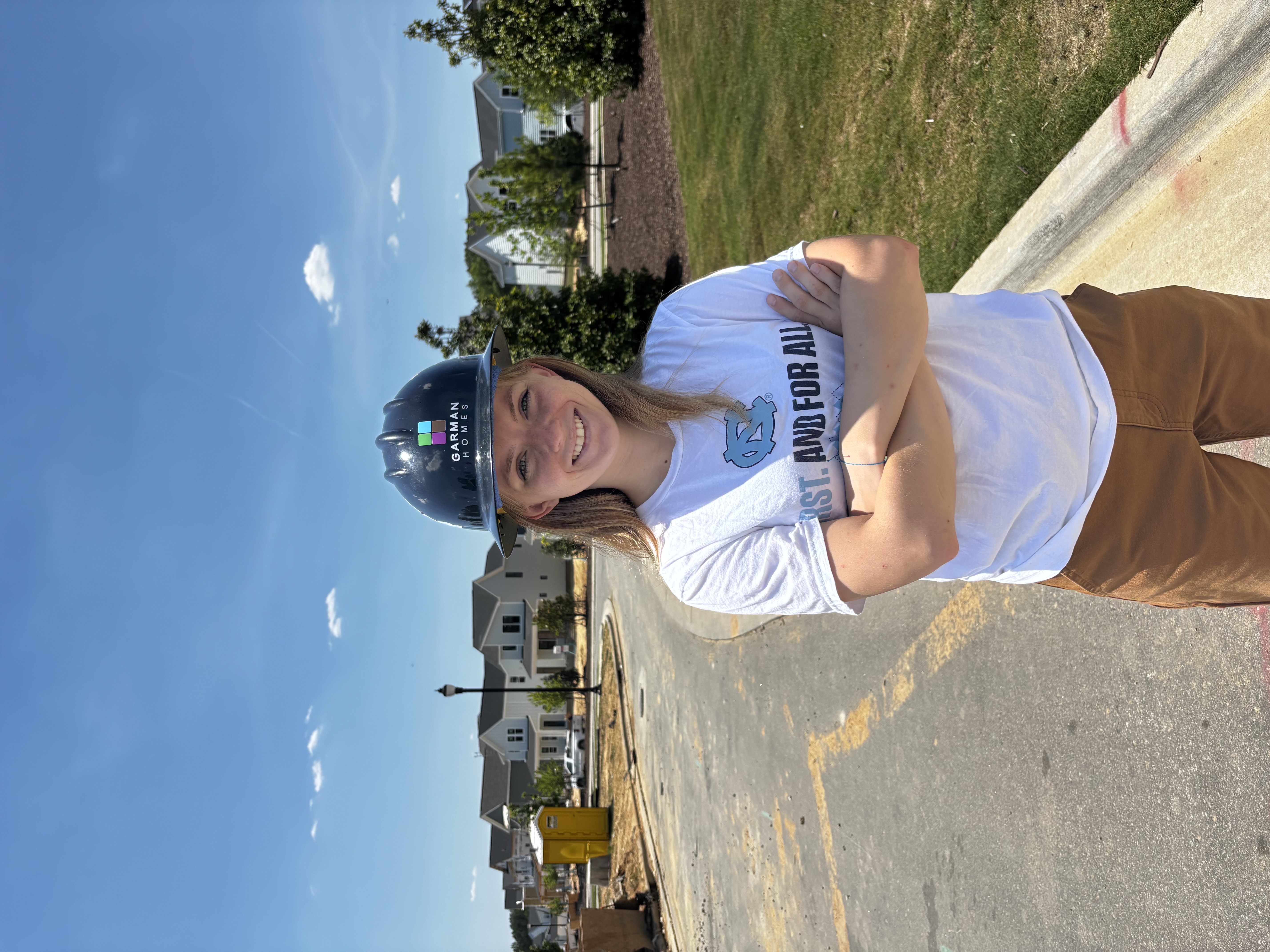 Meredith Clark in a hard hat on an unfinished road in a new housing development