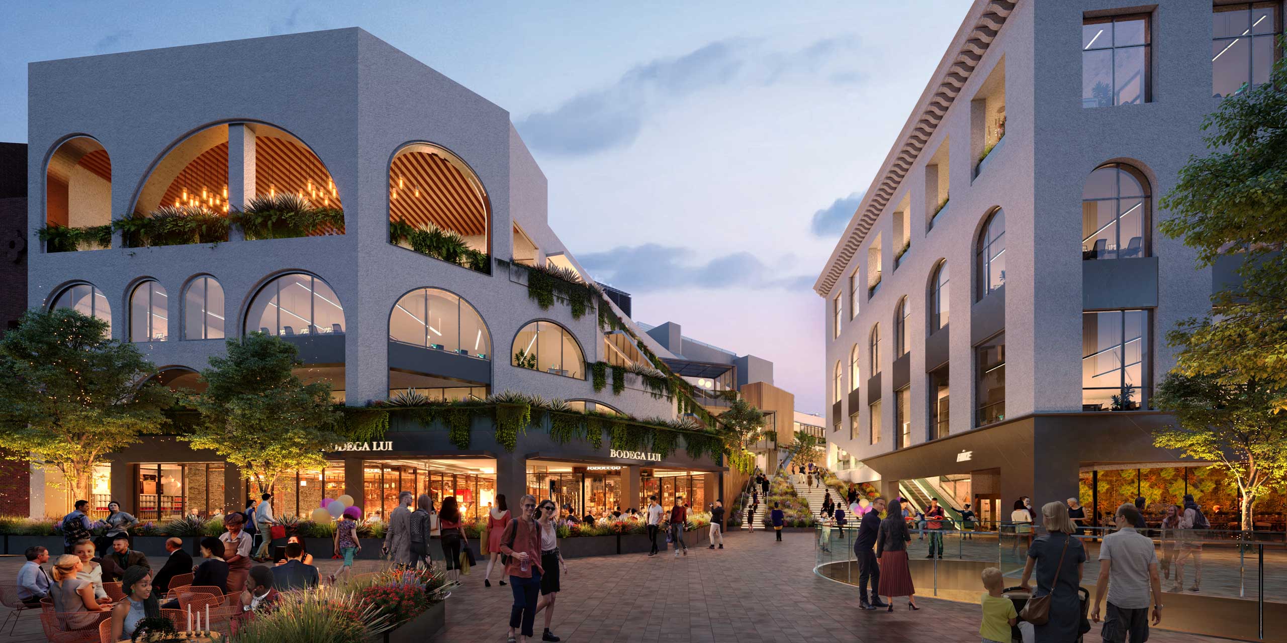 Pedestrian plaza with arched storefronts and plant-filled terraces at dusk